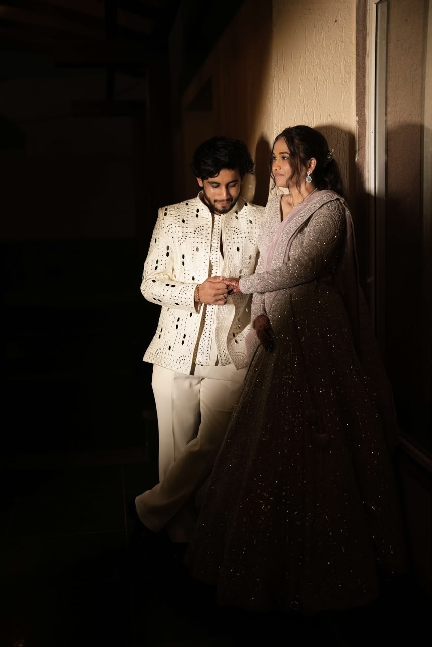 Sparsh holding Shanya's hand by lamplight